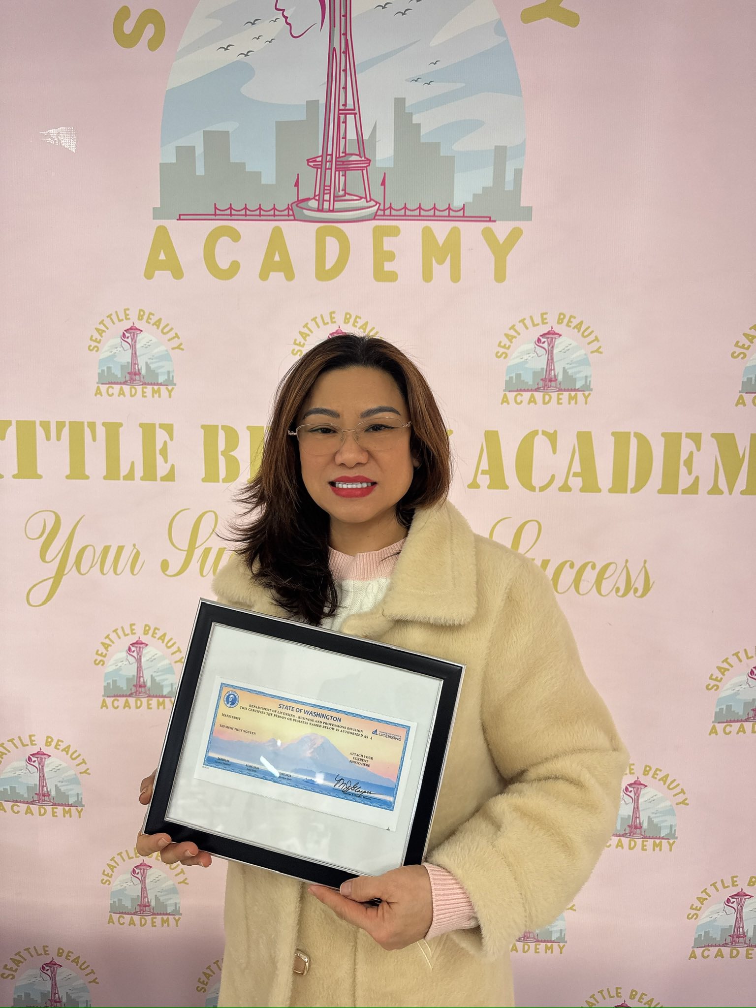 A new nail technician holding Washington State certificate at Seattle Beauty Academy campus A new nail technician holding Washington State certificate at Seattle Beauty Academy campus