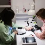 Modern nail salon setup with LED UV lamp, gel polish collection, and chrome nail art tools on technician workstation