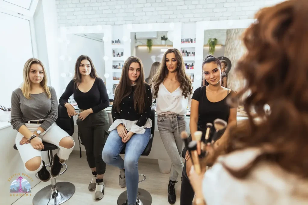 Small class of beauty students attentively listening to an instructor at a beauty school in Seattle