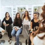 Small class of beauty students attentively listening to an instructor at a beauty school in Seattle