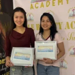 Seattle Beauty Academy graduates holding Washington State manicure licenses