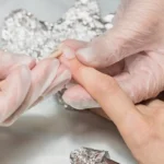 Nail tech implements soaking in EPA-registered disinfectant following Washington State sanitation standards