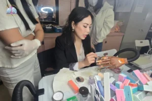 Seattle Beauty Academy instructor is demonstrating her student how to apply dip powder correctly with brush to prevent cross-contamination