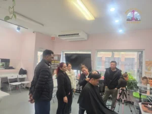 Barbering students and instructor at Seattle Beauty Academy observing a live haircut demonstration in the classroom