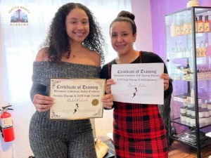 Body contouring certification graduates Rachel Rachinski and Diana Andino holding certificates of training at Seattle Beauty Academy