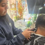 Seattle Beauty Academy barbering student practicing clipper technique on a live client during hands-on training