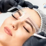 Esthetician measuring and mapping eyebrow shape with a ruler before a microblading treatment