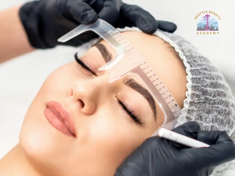 Esthetician measuring and mapping eyebrow shape with a ruler before a microblading treatment