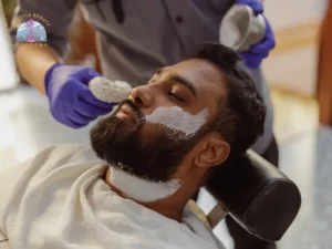 Student barber applying shaving cream during a professional beard grooming service at Seattle Beauty Academy's Seattle Barber course