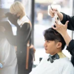 Beauty school student practicing hairstyling techniques during hands-on training