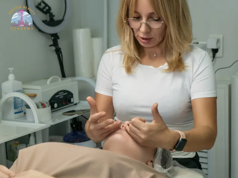 Esthetician performing facial massage for lifting during a client treatment at Seattle Beauty Academy