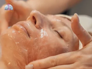 Esthetician smoothing forehead and temples during a lifting facial massage